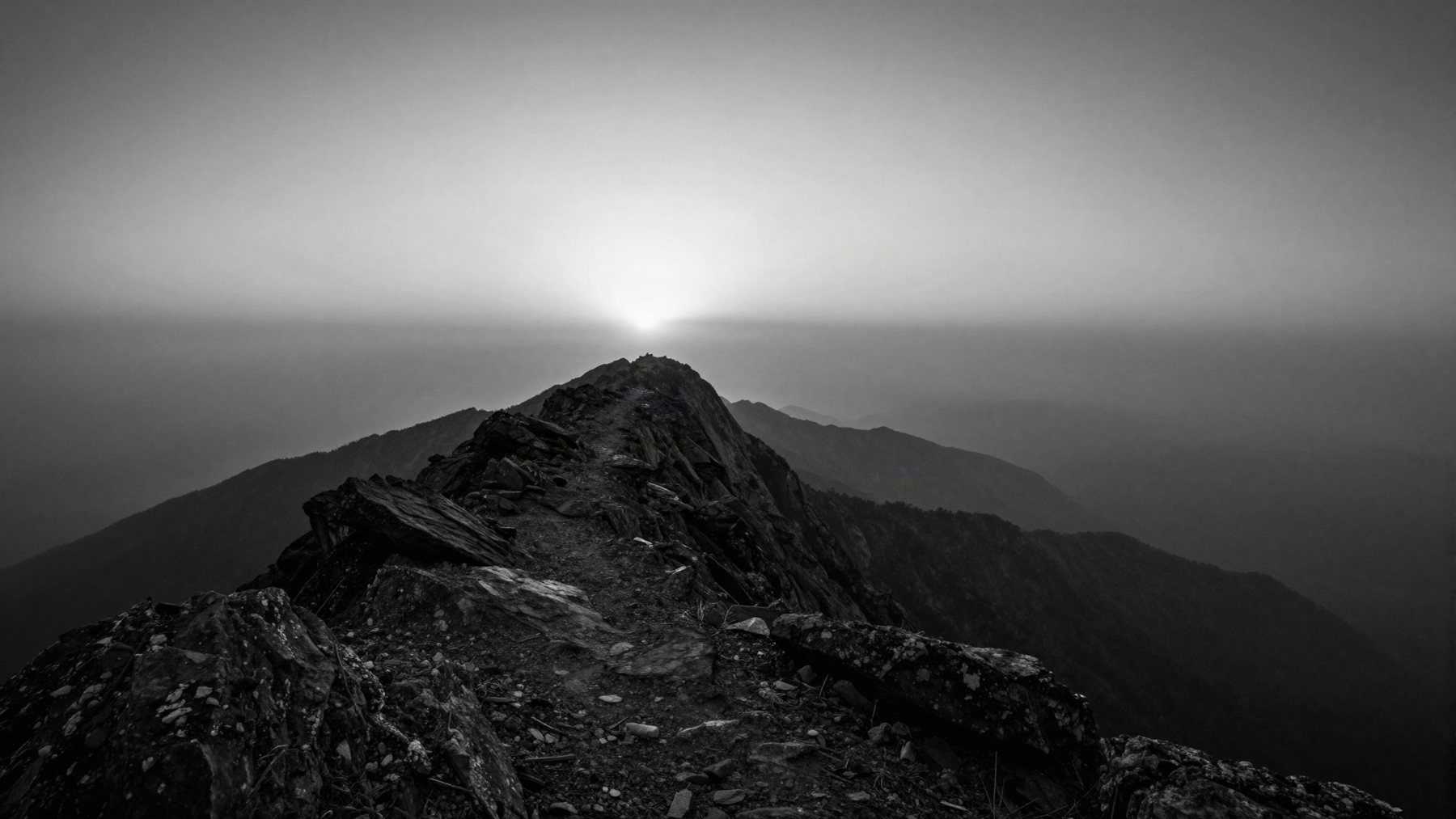 Rocky ridge leading toward a breaking dawn on the horizon